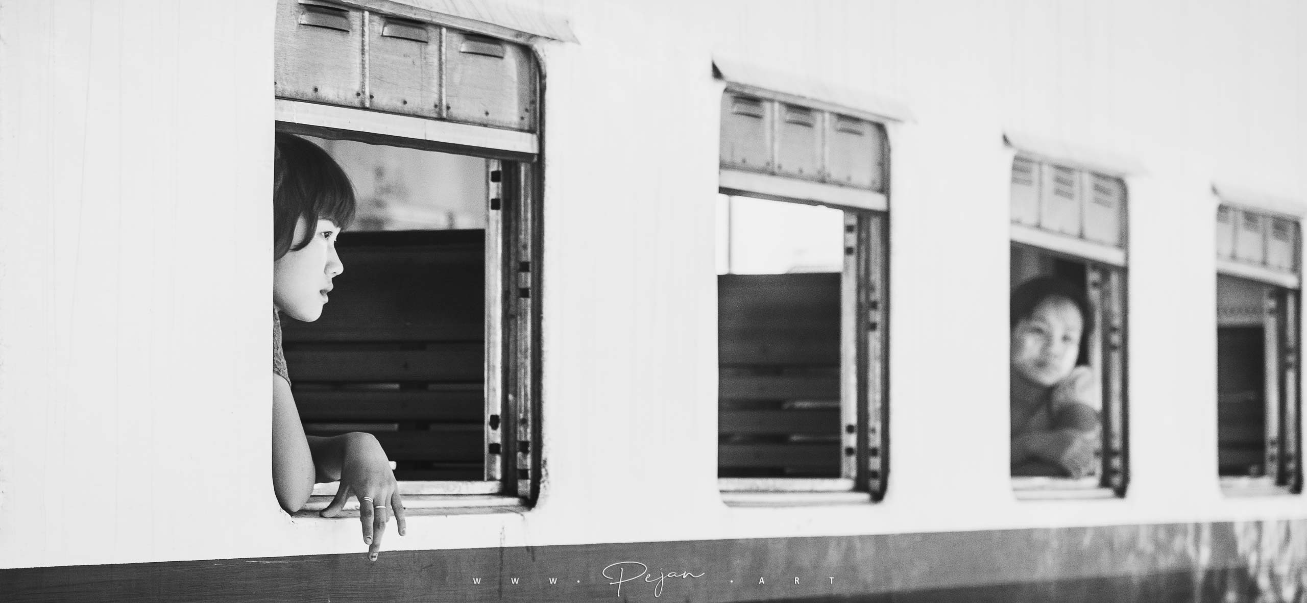Une jeune femme à la fenêtre d'un train dans le Sud de la Birmanie, Photographie de rue, monochrome, Noir et Blanc,