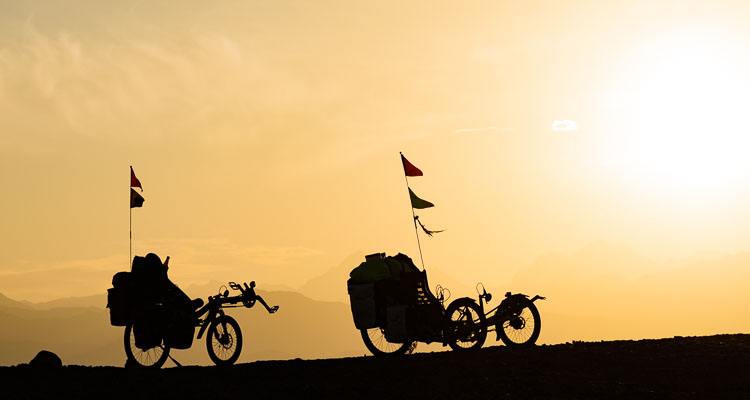 Silhouette de deux vélos couchés AZUB au coucher de soleil, Azub 6 et Azub Tricon, voyage à vélo en Iran, Aventure et bivouac aux confins du désert