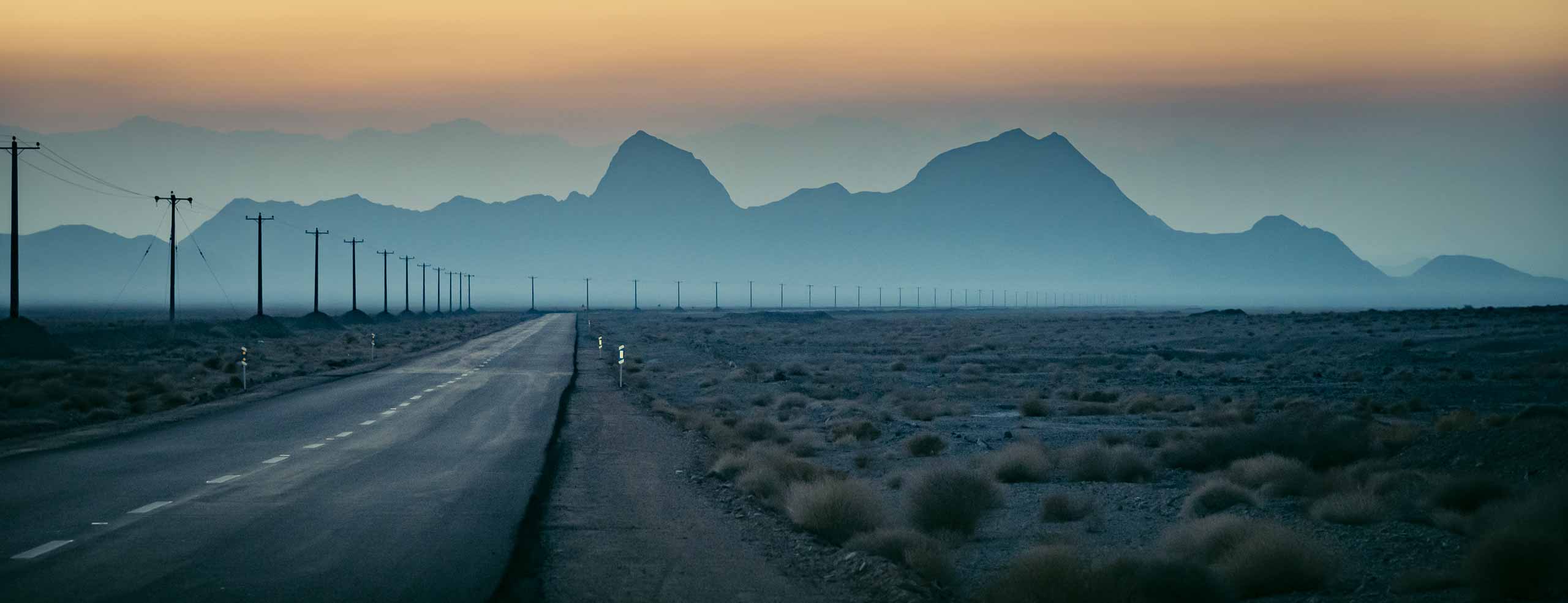 Une route s'étend vers l'infini aux portes du désert, près de Yazd, en Iran