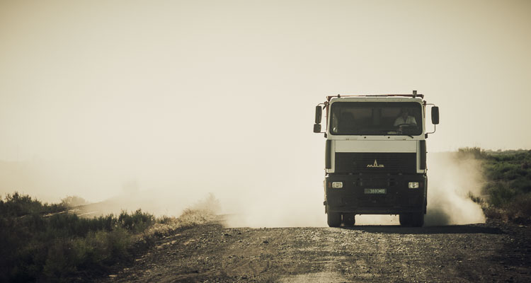 Truck on a dusty road in Turkmenistan in Central Asia, the atmosphere seems covered in dust - A cycling trip across Asia