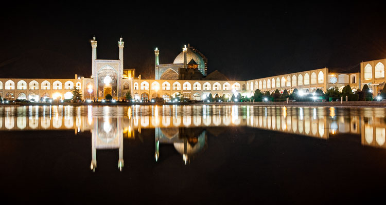 Photographie de la place Naqsh-e Jahan de nuit, réflexion de la mosquée illuminée dans une fontaine de la place, Symétrie, Meidan-e Emam, Ispahan, Iran