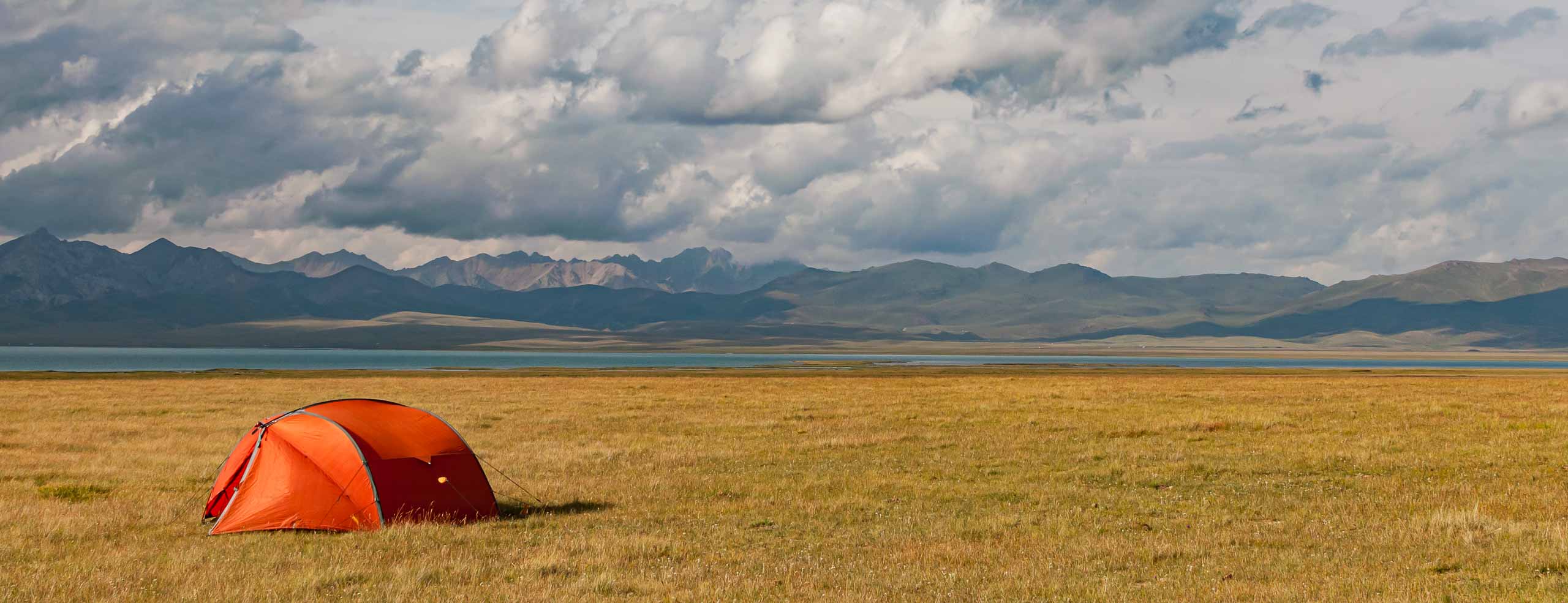 Bivouac dans une nature immense en Asie Centrale - Une tente rouge dans les monts Tian Shan, près du lac de Song Kul, Voyage au Kyrgyzstan, Asie Centrale