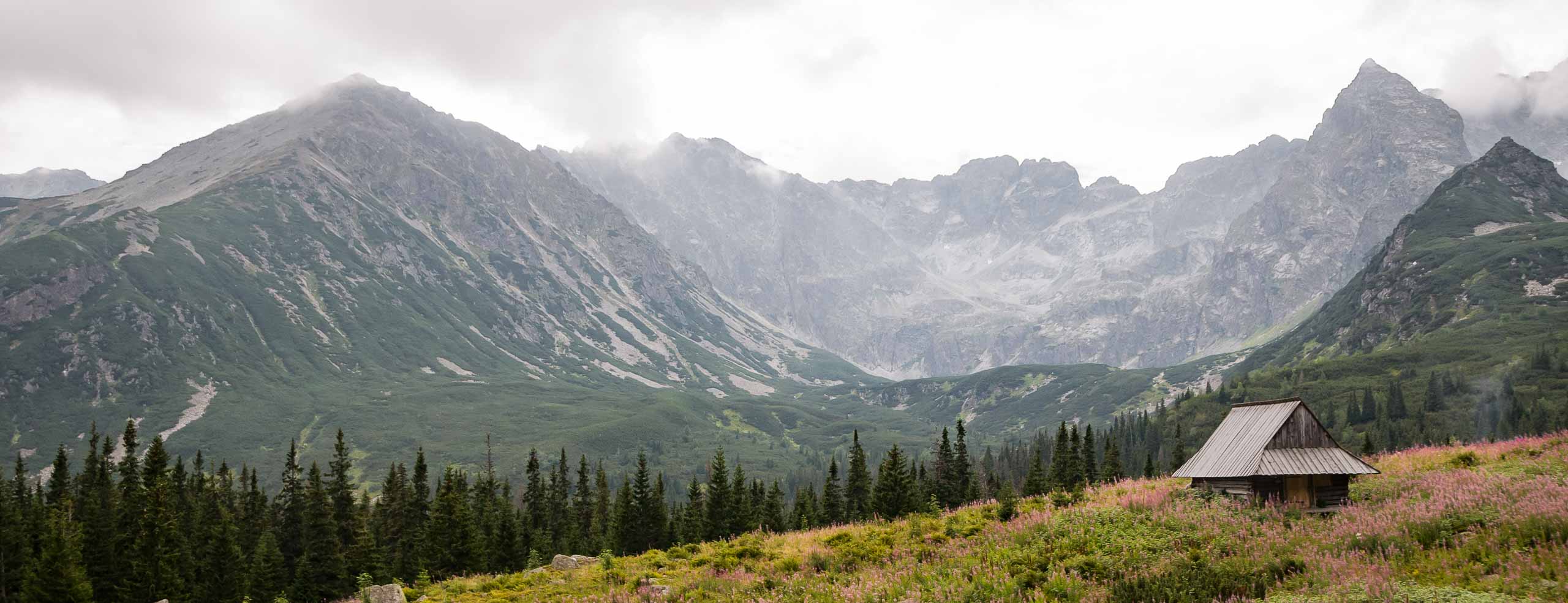 Randonnée dans les montagnes Tatras près de Zakopane en Pologne. Le temps est couvert, il y a une cabane en bois au premier plan.