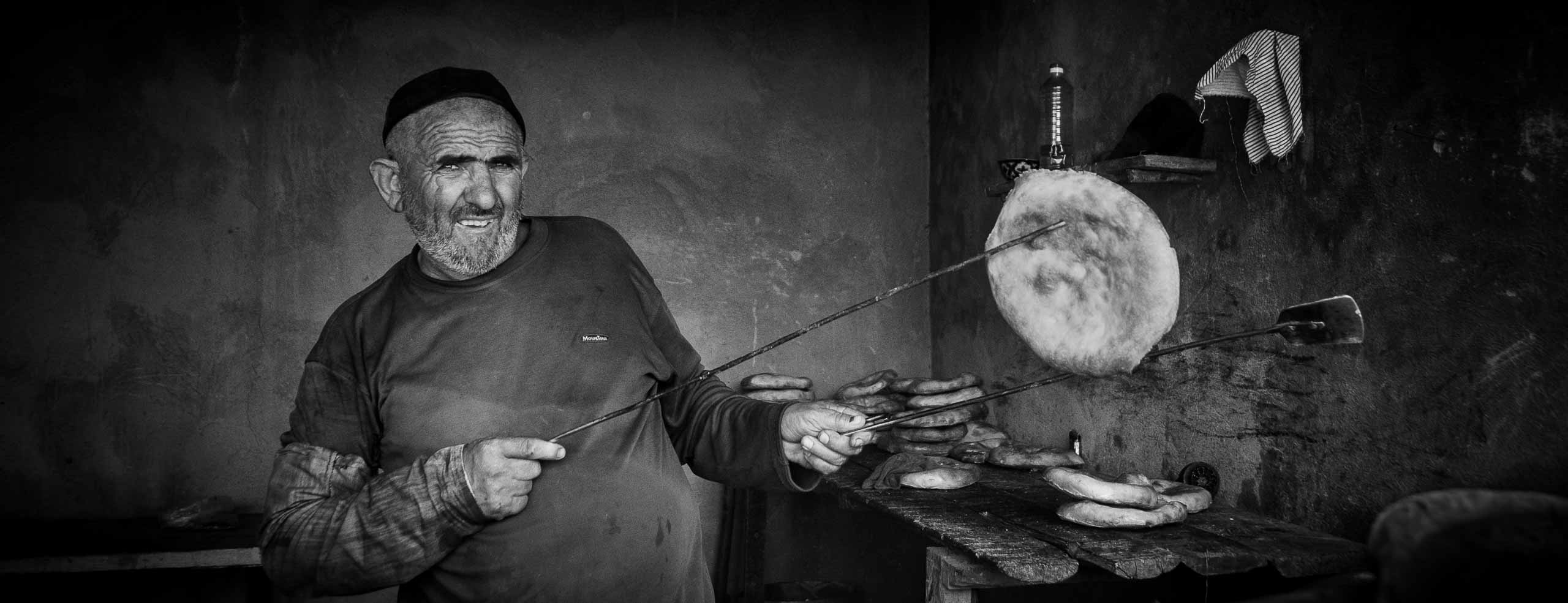 Portrait monochrome d'un boulanger Ouzbèke présentant un pain rond typique d'Asie Centrale, Sukhan-Darya, Ouzbékistan